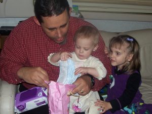 Daddy helping Sadie open her gifts.